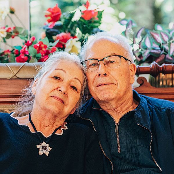 Annas Großeltern sitzen nebeneinander und schauen in die Kamera.