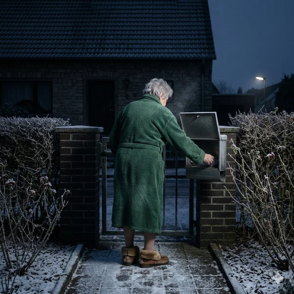 Nachts um drei nach der Post geschaut – wenn bei Demenz der Schlafrhythmus fehlt Ältere Person im Bademantel und Pantoffeln am Briefkasten im verschneiten Garten bei Nacht – wenn bei Demenz der Tag-Nacht-Rhythmus kippt