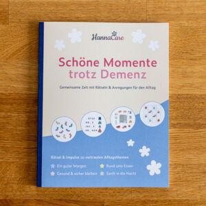 Beschäftigungsheft Schöne Momente trotz Demenz aus der Vogelperspektive auf einem Holztisch fotografiert