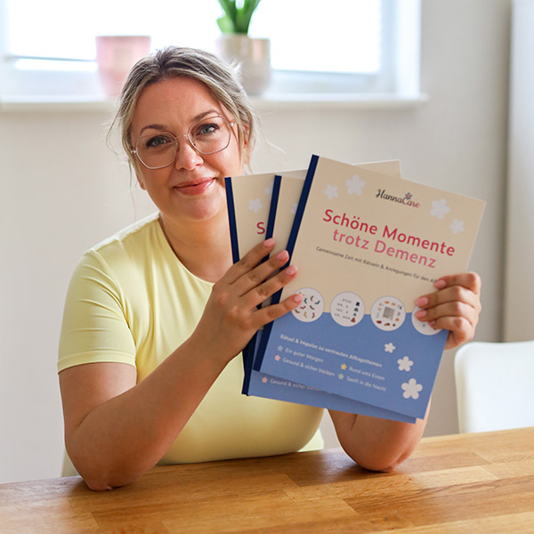 Anne sitzt am Tisch und zeit das Beschäftigungsheft